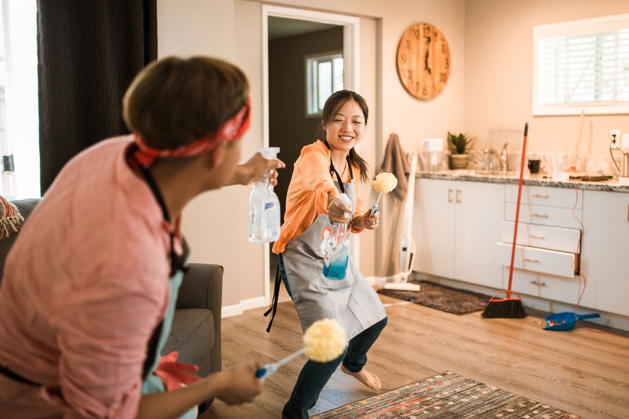 hero-img-02 Asian couple having fun while cleaning their home, creating a cheerful atmosphere.
